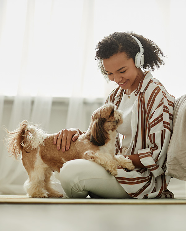 young woman at home petting her little dog
